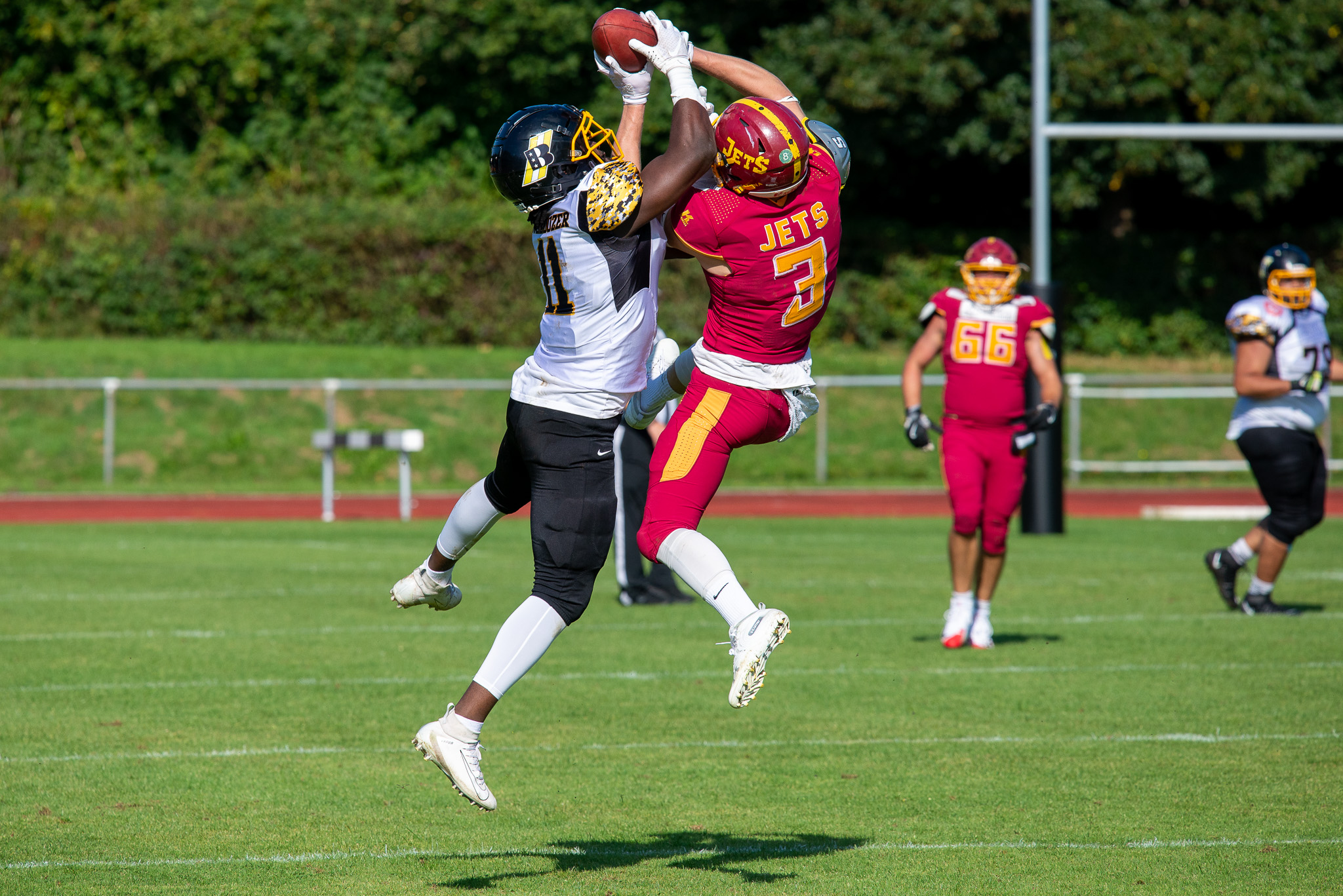 Im Aggerstadion verloren die Troisdorf Jets gegen den Aufsteiger, die Düsseldorf Bulldozer - Duell zwischen Kwofi Harlan #11 (weißes Trikot) und Jona Glasner #3 (rotes Trikot) - Foto: Oliver Jungnitsch